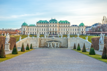 Ein prächtiger barocker Palast mit grünen Kupferkuppeln, symmetrischer Architektur und kunstvollen Statuen im Garten, der zum Hauptgebäude des Oberen Belvedere in Wien, Österreich führt.